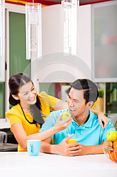 Asian woman feeding boyfriend with apple