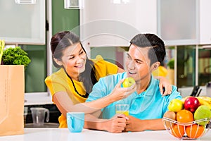 Asian woman feeding boyfriend with apple