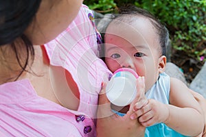 Asian woman feeding her baby from top