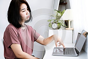 Asian Woman Feeling Bored and Lacking Inspiration to Start Working, Sitting in Front of Computer with No Ideas