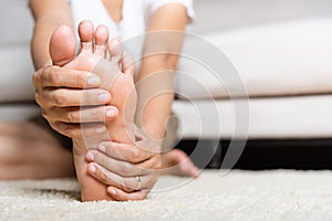 Asian woman feeling pain in her foot at home