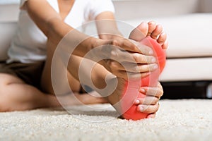 Asian woman feeling pain in her foot at home