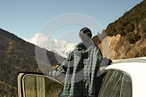 Asian woman female tourist looking at snow covered mount kawaboge in yunnan, china