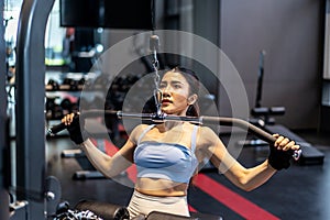 Asian woman fitness exercises at gym lat pulldown machine, Making an effort and training hard for fit body, Healthcare,