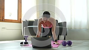 Asian woman fitness trainer conducting virtual yoga class with group of people at home on a video conference. Fitness