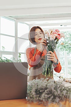 Asian woman Florist holding bouquet in flower shop