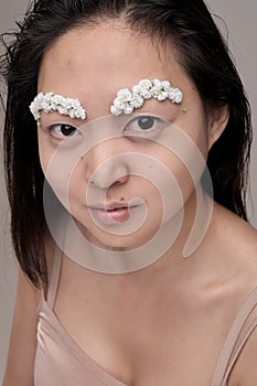 Asian woman with flowers on her face