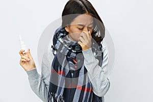 Asian woman flu cold with stuffy nose holding allergy and virus nasal spray with sore throat on white background