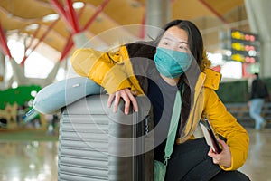 Asian woman flying in covid19 times - lifestyle portrait of young happy and pretty Japanese girl in face mask waiting on airport