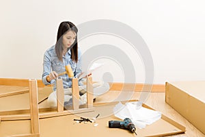 Asian woman follow instruction for assembling chair