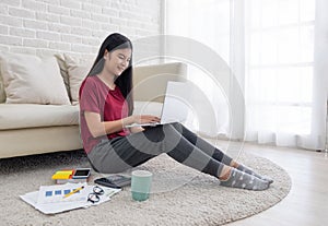 asian woman freelance working on laptop with paperwork at home,work at home concept.online learning concept.