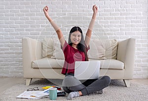 Asian woman freelancer arms up and smile for success working on