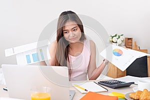 Asian woman freelancer upset with work problem with laptop on mess table.work at home concept.stress working