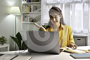 Asian woman freelancer working on computer at home. Attractive businesswoman studying online, using laptop software