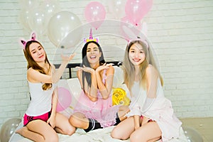 Asian woman friend group attractive sexy,celebrating private party,relaxation on bed white bedroom house full balloons,cheerful