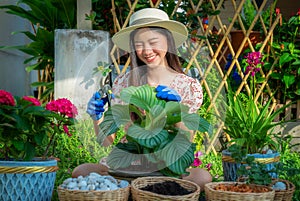 Asian woman gardener relax in her home garden with flower pot