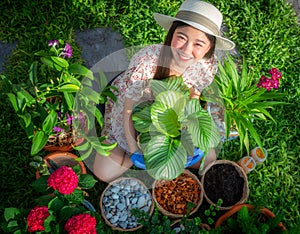 Asian woman gardener relax in her home garden with flower pot