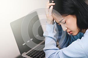 An asian woman getting anxiety and depression after checking news about global pandemic