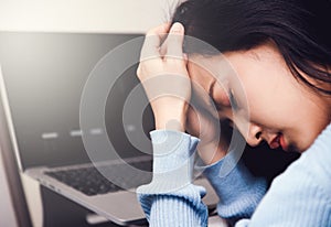 An asian woman getting anxiety and depression after checking stock market news about global pandemic