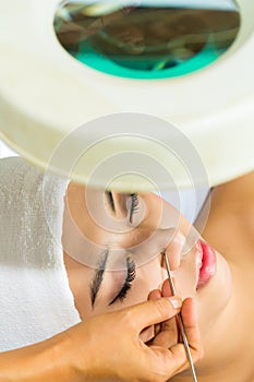 Asian woman getting a facial treatment in spa photo