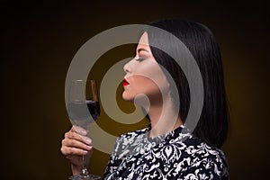 Asian woman with glass of red wine