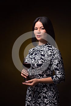 Asian woman with glass of red wine