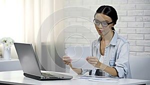 Asian woman in glasses reading letter, subpoena, receipt of correspondence photo