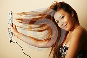 Asian woman with hair straightener