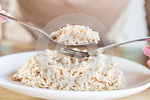 Asian woman hand eating healthy brown rice closeup