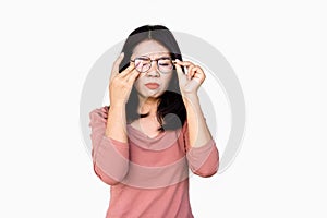 Asian woman hand holding eyeglasses the other hand rubbing her eye pain, blur vision standing isolated on white background