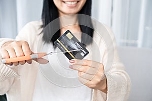 Asian woman hand holding scissors cutting credit card financial, debt freedom concept