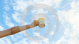 Asian woman hands hold hot coffee mug outdoor on clear sky background with copy space. Enjoy drinking coffee in the morning.