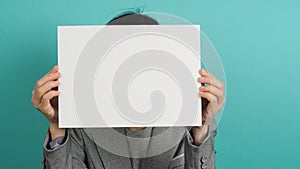 Asian woman hands holding blank paper board and wear grey suit  on blue or green mint background