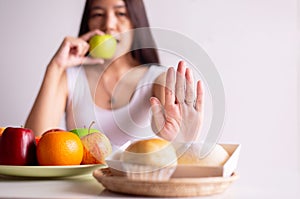 Asian woman hands stop to bread and holding green apple on white background,Healthy diet,Dieting concept