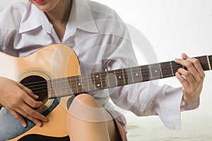 Asian woman hands touching guitar chords