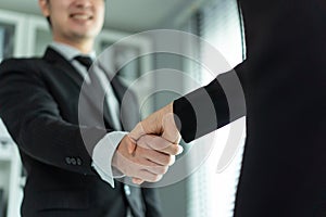 Asian woman handshake with hr manager after job interview in office. Attractive beautiful female employee shake hands with human