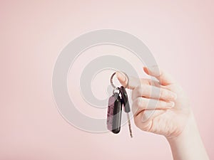 Asian woman hanging car key by beauty right hand with pink paste