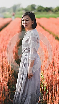 Asian woman happily walking and taking pictures in the flower garden