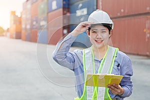 Asian woman happy dock worker control loading containers cargo at shipyard. Marine and carrier staff manager employee. cargo