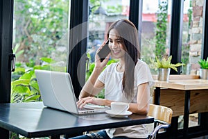 Asian woman or a happy student smiles on a desk with a computer