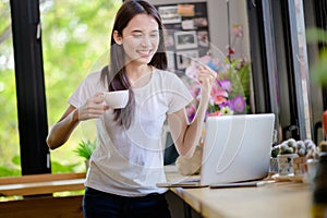 Asian woman or a happy student smiles on a desk with a computer