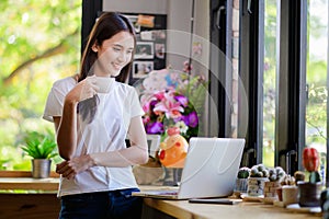 Asian woman or a happy student smiles on a desk with a computer