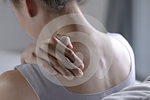 Asian woman has shoulder pain. Female holding painful shoulder with another hand. People with body-muscles problem