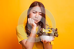 Asian woman hate salad in yellow dress