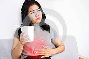Asian woman have burning pain in her stomach after eating spicy noodles feeling heartburn from gas