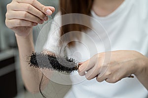 Asian woman have problem with long hair loss attach to comb brush