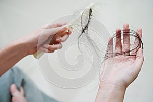 Asian woman have problem with long hair loss attach in her hand