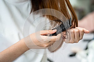 Asian woman have problem with long hair loss attach to comb brush