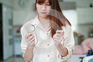 Asian woman have problem with long hair loss attach to comb brush