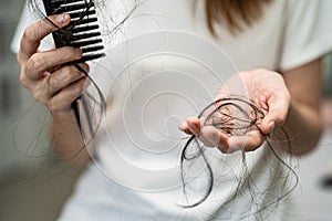 Asian woman have problem with long hair loss attach to comb brush